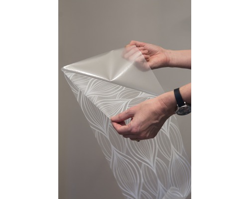 Rolu tapety so vzorom držia dve ruky.