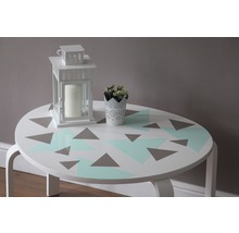 Dekoratívny stôl s geometrickým vzorom, lampášom a kvetom v kvetináči