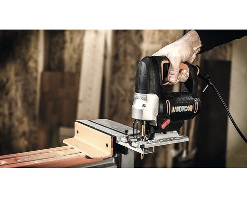 Ruka drží priamočiaru pílku pri rezaní dreva