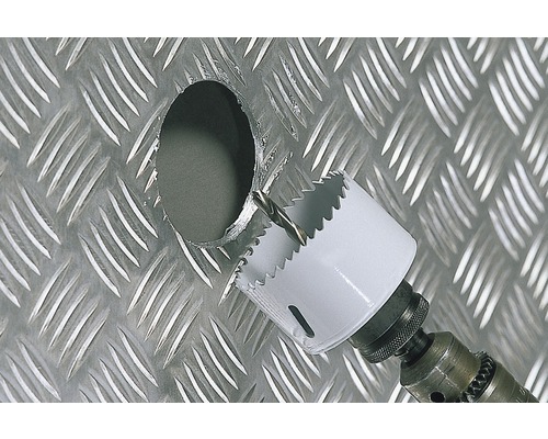 Dierová píla vŕta otvor do kovovej dosky