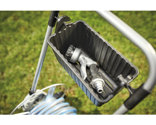 Záhradný hadicový vozík so záhradným postrekovačom v odkladacej priehradke