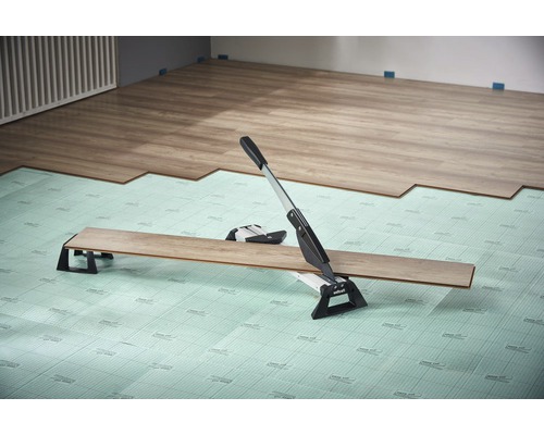 Rezačka laminátu v prevádzke na kročajovej izolácii pri ukladaní laminátu