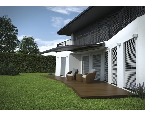 Pohľad na dom s markízou, terasou a záhradným nábytkom