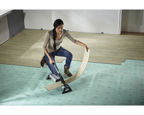 Žena reže laminát rezačkou laminátu na podložke