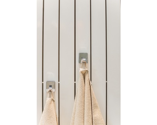 Dva uteráky visia na hákoch v kúpeľni