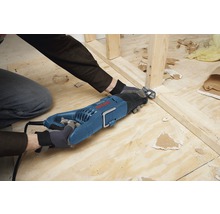 Muž reže drevený rám vratnou pílou