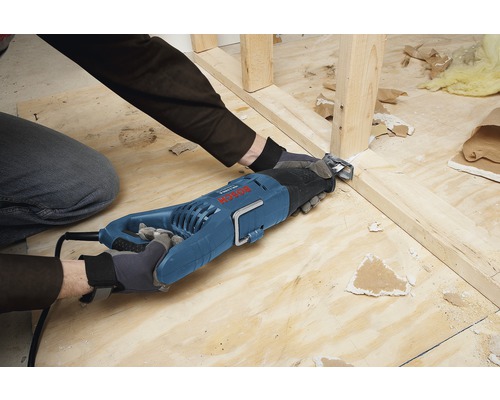 Muž reže drevený rám vratnou pílou