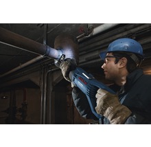 Muž s ochrannou helmou a okuliarmi reže rúru pomocou šabľovej píly Bosch.