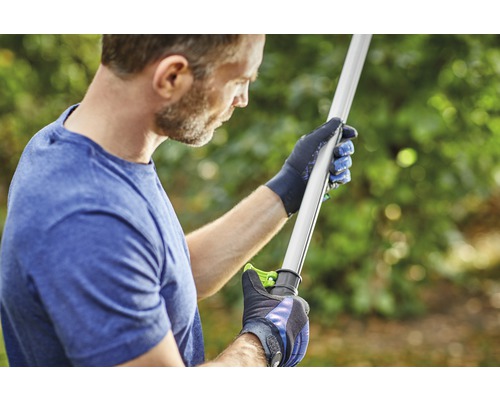 Osoba v rukaviciach drží záhradné náradie.