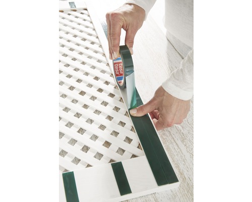 Aplikácia obojstrannej lepiacej pásky Tesa na bielu drevenú mrežu