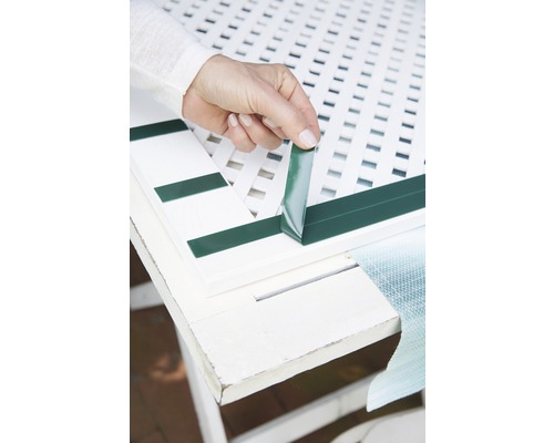 Osoba pripevňuje prúžky na ochranu súkromia k plotovému dielu