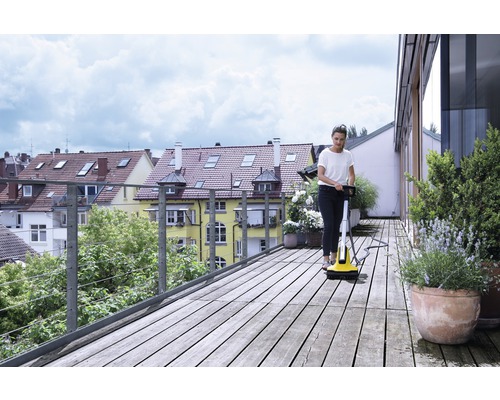 Žena čistí drevenú terasu čističom terás