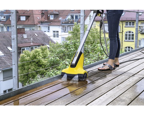 Žena čistí drevenú terasu pomocou čističa terás Kärcher