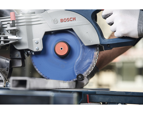 Logo Bosch. Pokosová píla reže kus kovu.