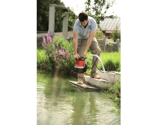 Muž obsluhuje kalové čerpadlo na brehu vodnej plochy.