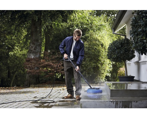 Muž čistí vonkajšie schodisko vysokotlakovým čističom.