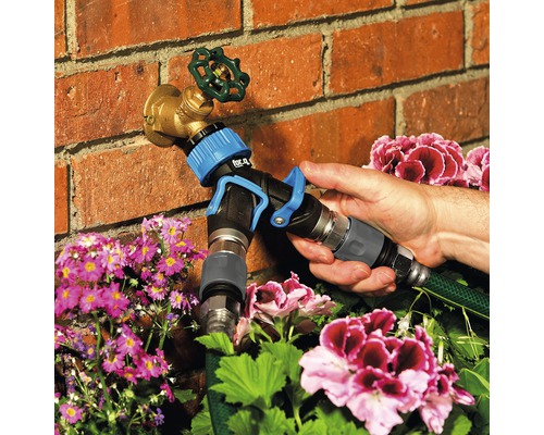 Adaptér záhradnej hadice pripevnený k vodovodnému kohútiku na zavlažovanie záhrady.