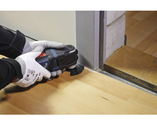 Operátor používa multifunkčný nástroj na rezanie na drevenej podlahe