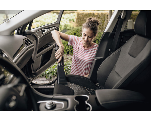 Žena vysáva autosedačky vysávačom