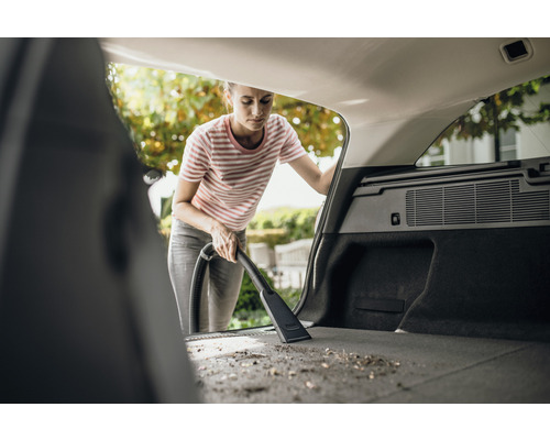 Žena vysáva kufor auta vysávačom