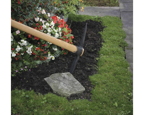 Záhradnícka scéna s krompáčom, kvetmi a trávou