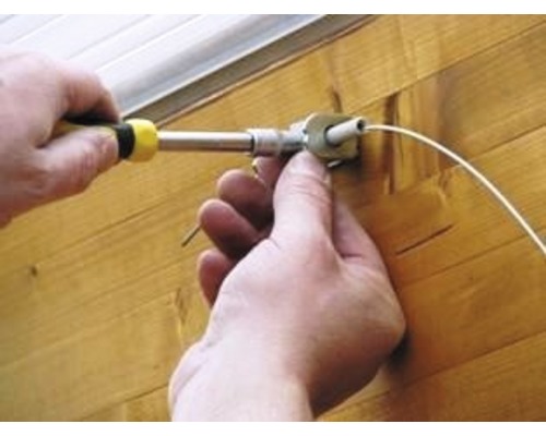 Osoba montuje žalúzie pomocou skrutkovača.