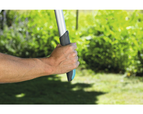 Ruka drží záhradné náradie s rukoväťou v záhrade