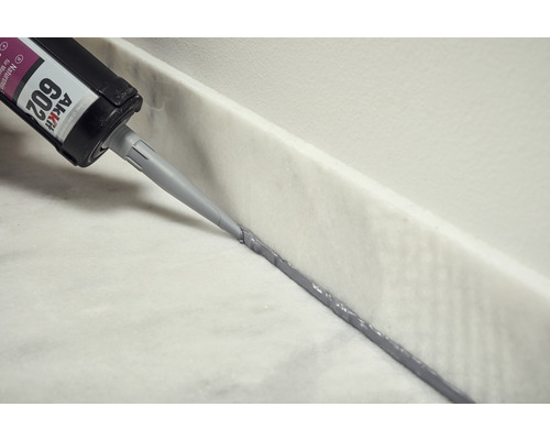 Aplikácia prírodného kamenného silikónu z kartuše na mramorový povrch.