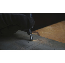 Osoba používa multifunkčný nástroj na vyrezávanie kusu dreva.