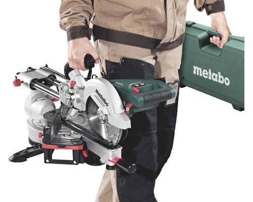 Osoba nesie pokosovú pílu Metabo a kufrík na náradie Metabo.