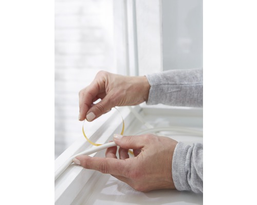 Aplikácia tesniacej pásky na okenný rám na utesnenie