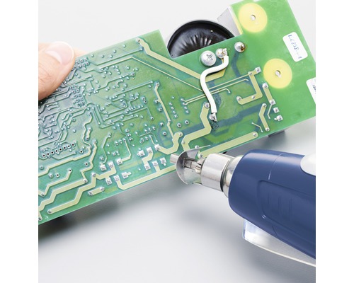 Osoba opravuje dosku plošných spojov pomocou spájkovačky.