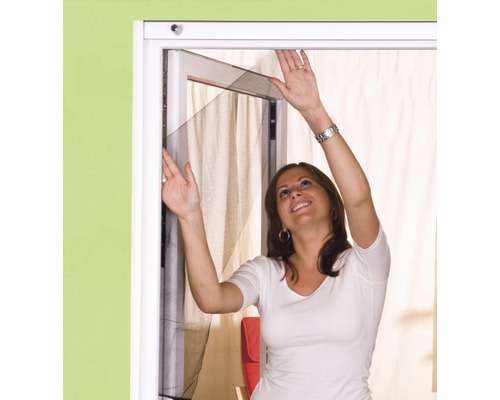 Žena inštaluje sieť proti hmyzu na okno