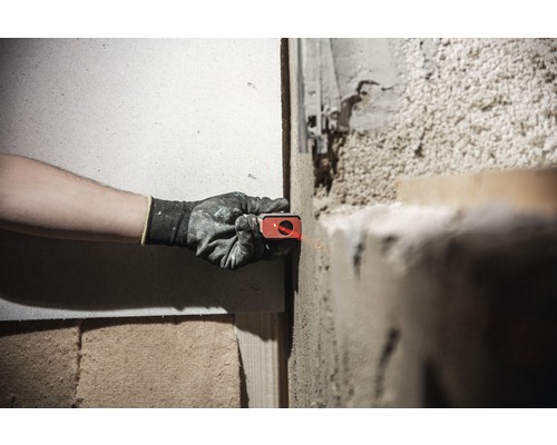 Osoba používa laserovú vodováhu na stene na vyrovnanie projektu.