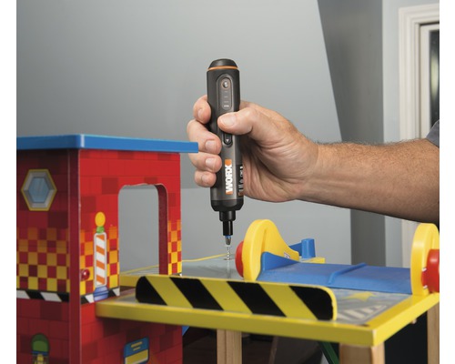 Osoba používa akumulátorový skrutkovač na hračke.