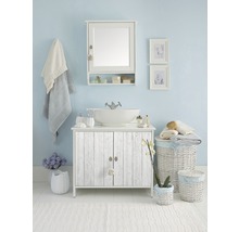 Svetlá kúpeľňa s umývadlovou skrinkou, zrkadlom, uterákmi a dekoráciami.