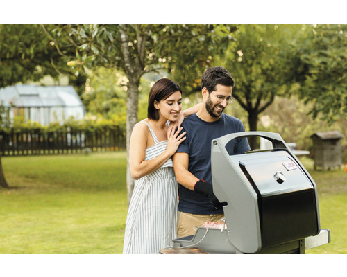 Pár griluje v záhrade s plynovým grilom