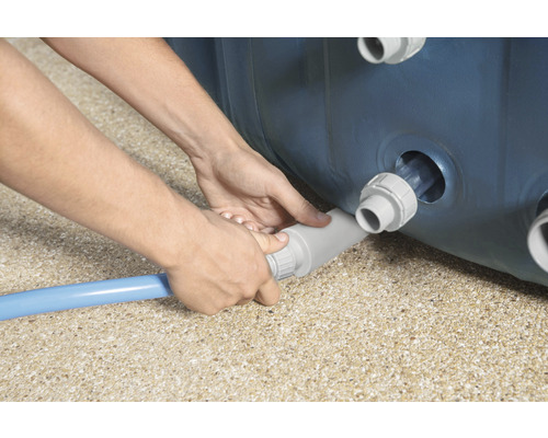 Osoba pripája bazénovú hadicu k bazénu.