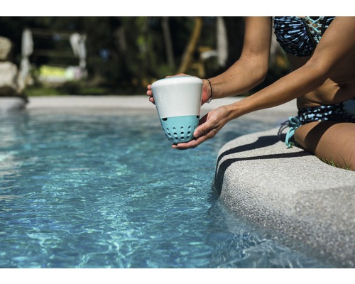 Žena drží dezinfekciu vody pri okraji bazéna