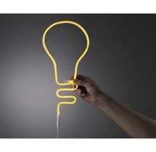 Ruka drží neónovú lampu v tvare žiarovky