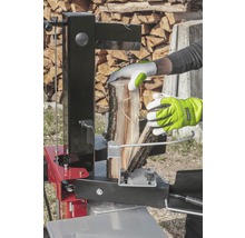 Osoba štiepa drevo pomocou štiepačky.