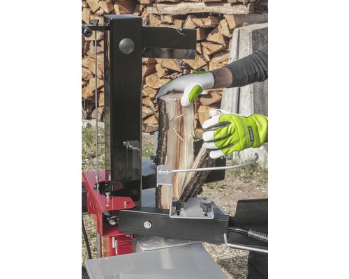 Osoba štiepa drevo pomocou štiepačky.