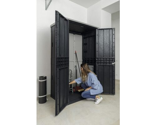 Otvorená plastová skriňa na náradie s uloženými vecami a osobou pred ňou.