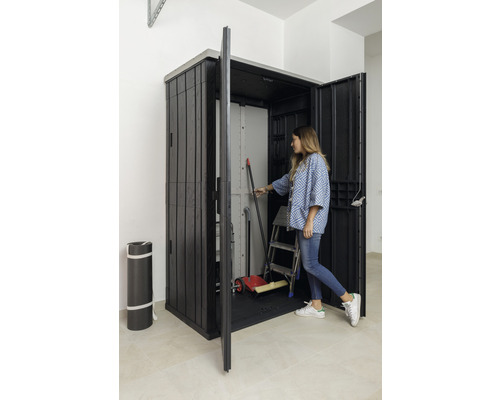 Plastová skriňa na náradie s otvorenými dverami a ženou, ktorá do nej siaha, aby si zobrala náradie