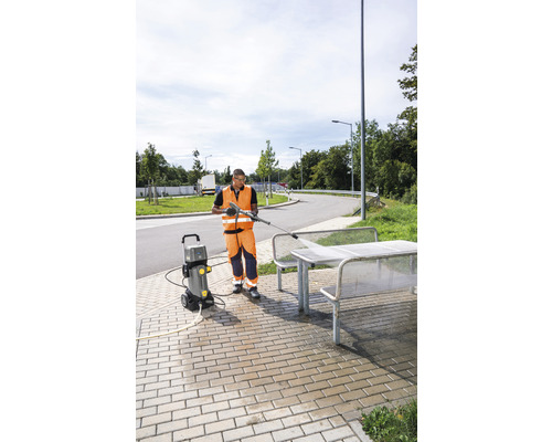 Osoba používa vysokotlakový čistič na čistenie vonkajšieho sedenia.