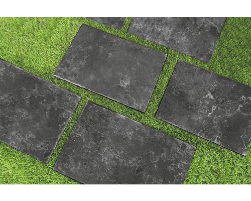 Sivé kamenné dosky na trávniku pre záhradné chodníky