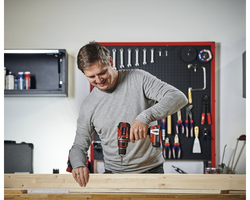 Muž pracuje s akumulátorovým skrutkovačom na dreve v dielni