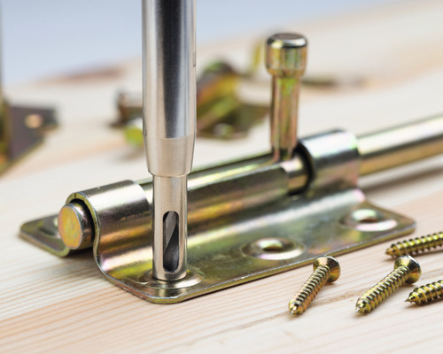 Kovová závora dverí namontovaná skrutkami na drevo