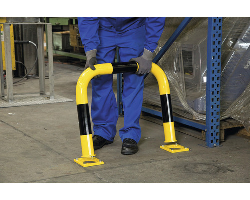 Osoba inštaluje ochranný oblúk proti nárazu v sklade.