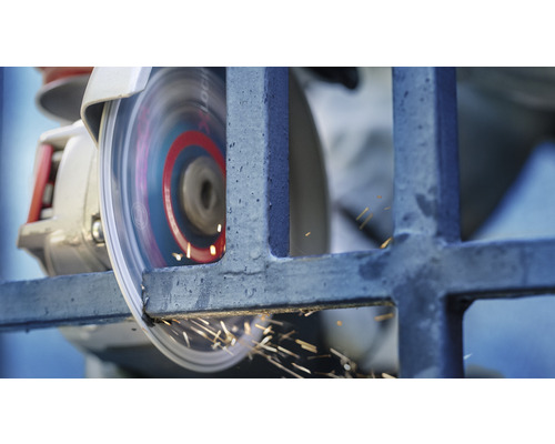 Kovová mriežka je opracovávaná uhlovou brúskou, pričom vznikajú iskry.